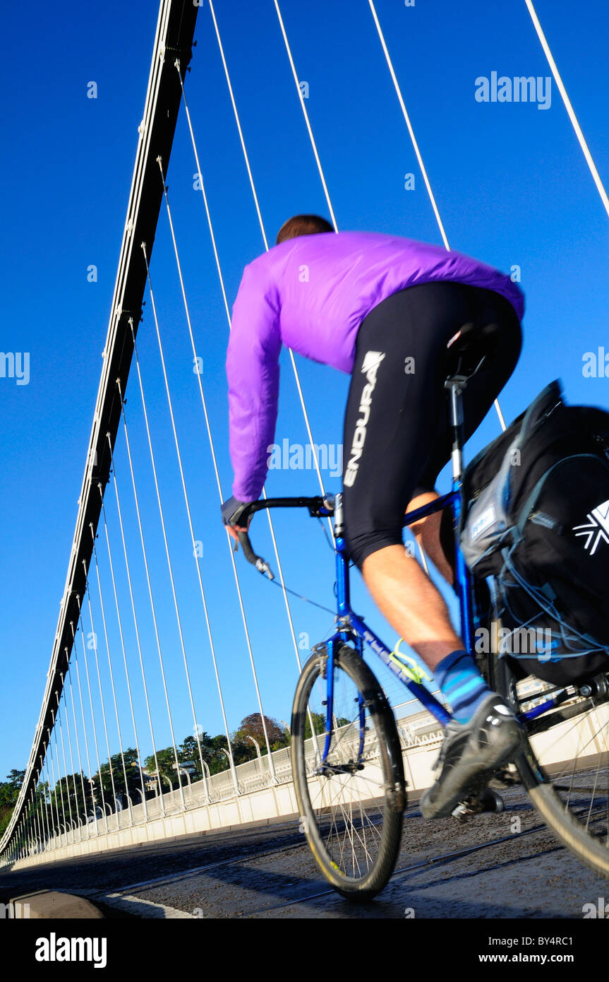 A fine sunny morning on Bristol`s famous Clifton suspension bridge with a cyclist in mauve passing by. Stock Photo